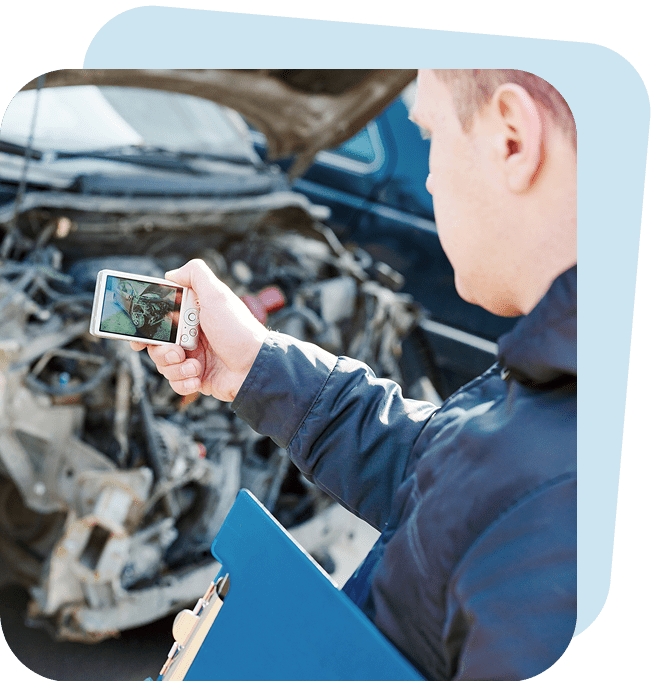 Man photographing car damage with smartphone.