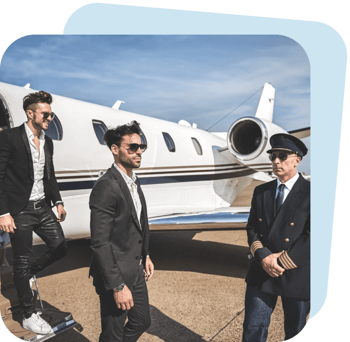 Three men in suits standing near a private jet under a clear sky.