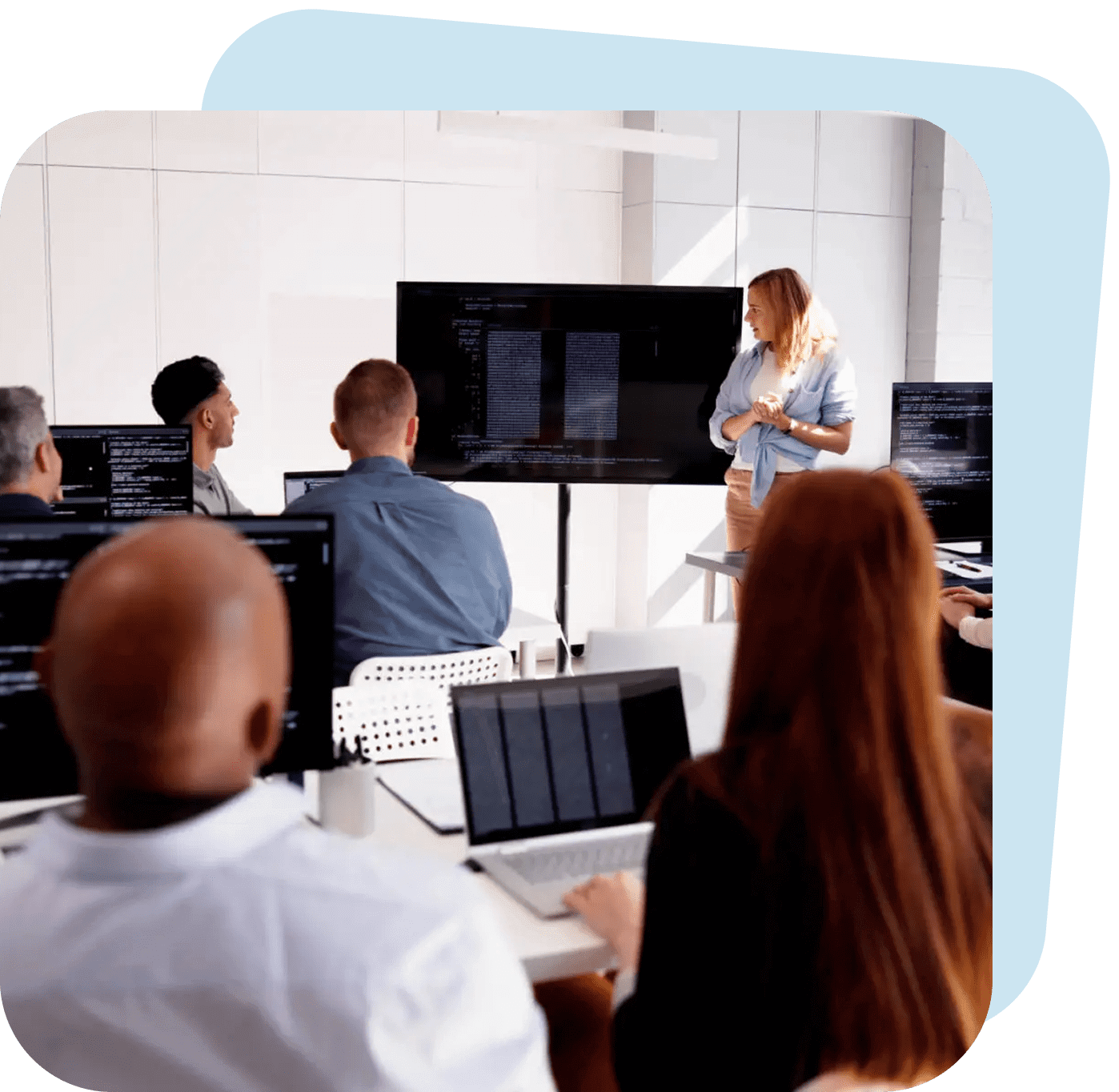People attending a presentation in a modern conference room.